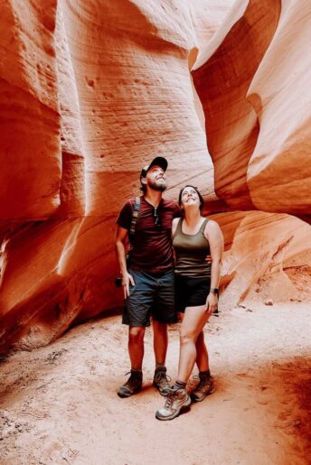 Ron and Jess standing and looking up at the smooth orange walls of lower antelope canyon