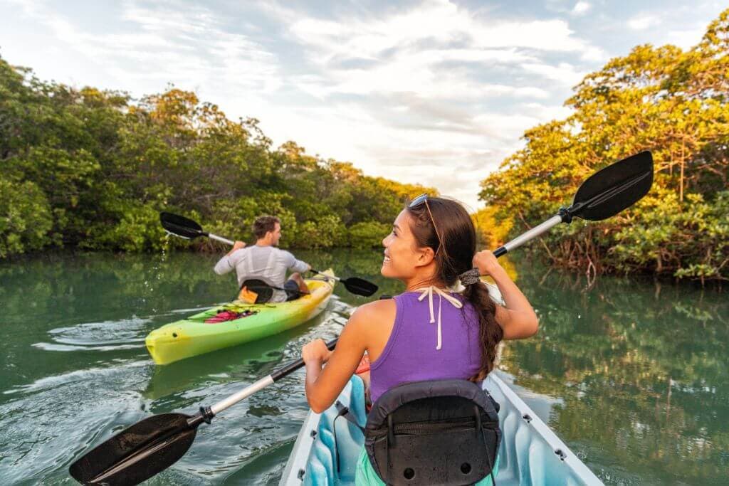 a man and women kayaking down a river 
