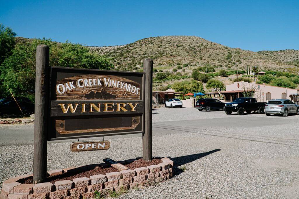 the oak creek winery sign in sedona in the parking lot that reads open