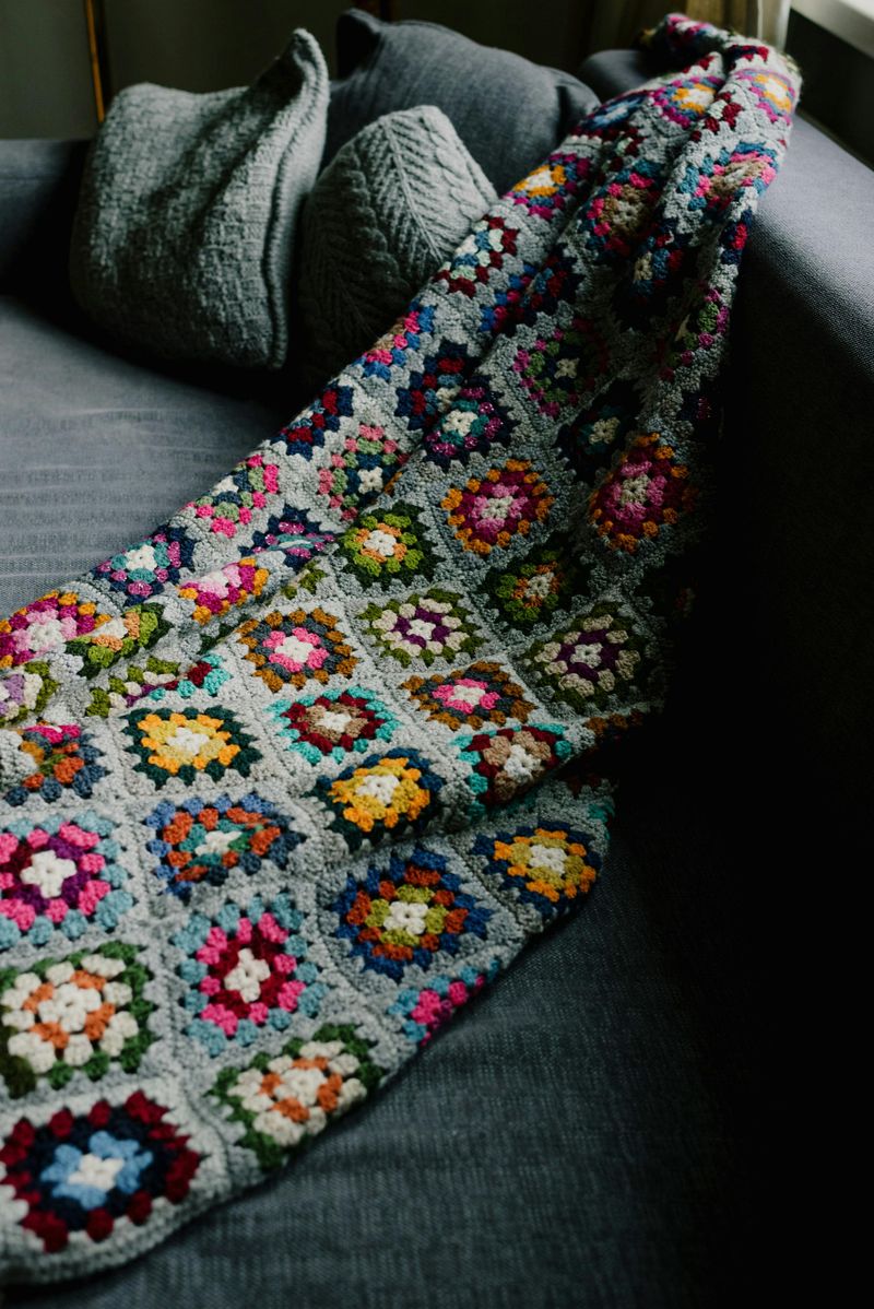 A crocheted afghan or blanket draped over the couch
