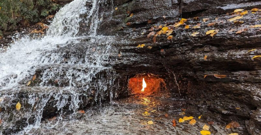 This Orchard Park Waterfall Has A Natural Flame Burning Behind The Cascade