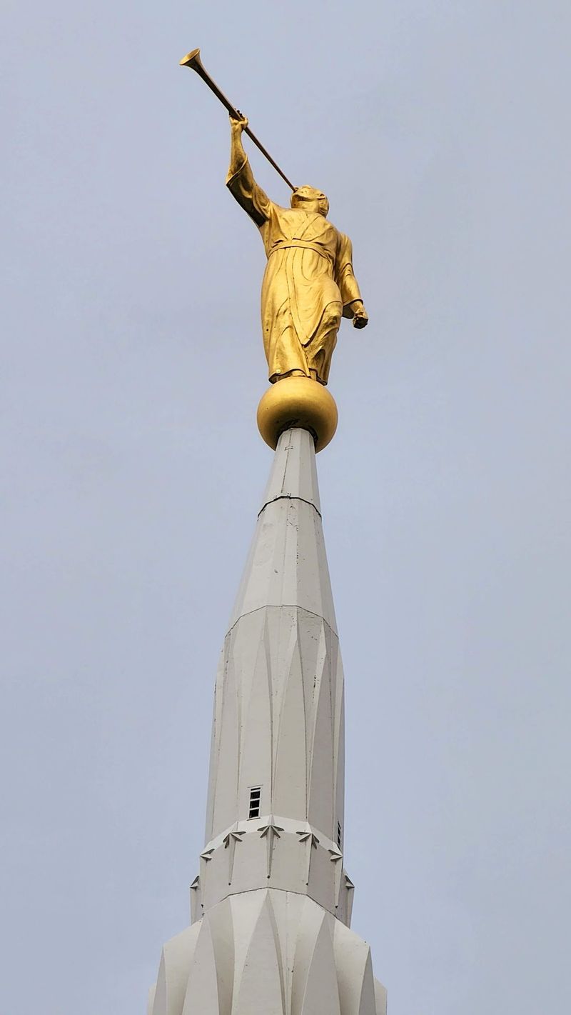The Gold-Crowned Spire and Its Trumpeting Figure