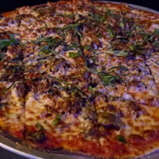 This Wisconsin Speakeasy Hides in an Old Italian Workers Club and Serves Tavern-Style Pies Diners Call Madison’s Best