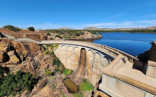 This Oklahoma Dam Towers Over a Still Lake With Views So Calm They Barely Look Real