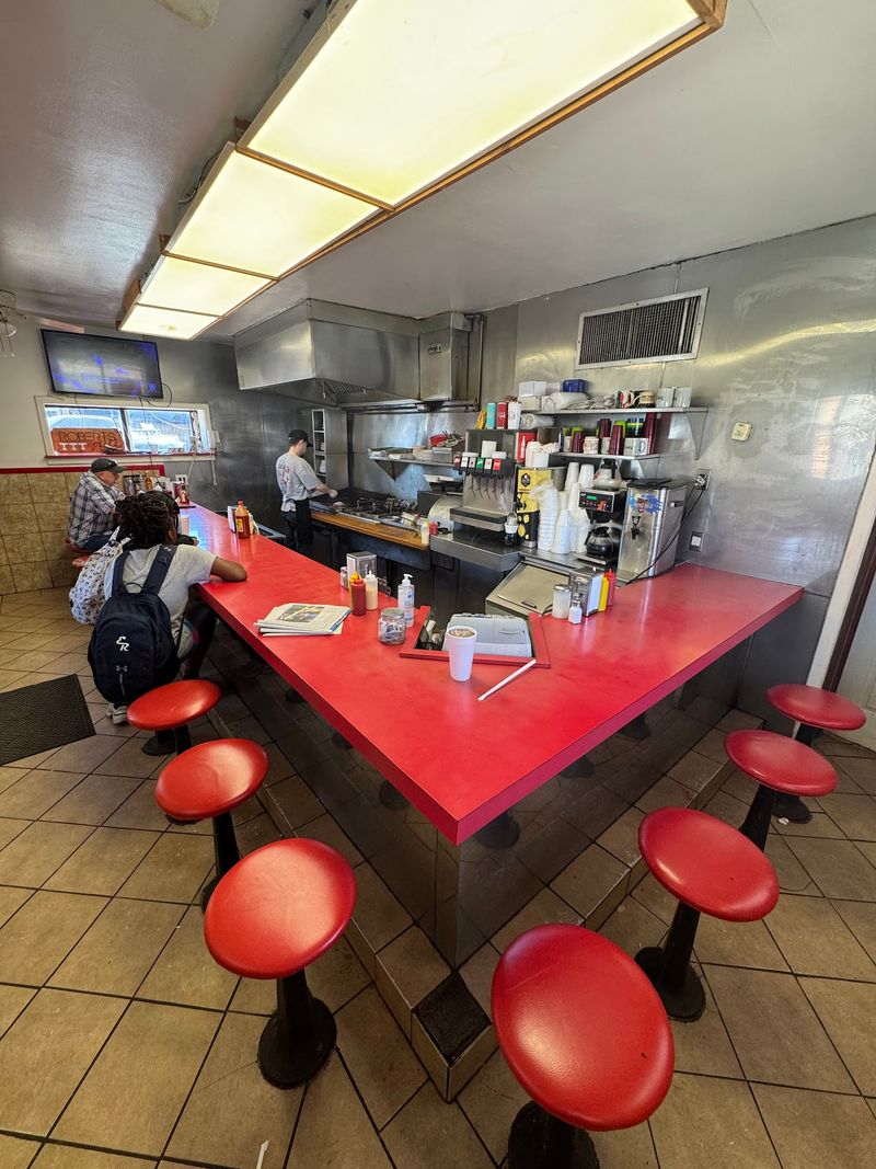 Front-Row Stools Facing a Well-Worn Griddle Front-Row Stools Facing a Well-Worn Griddle