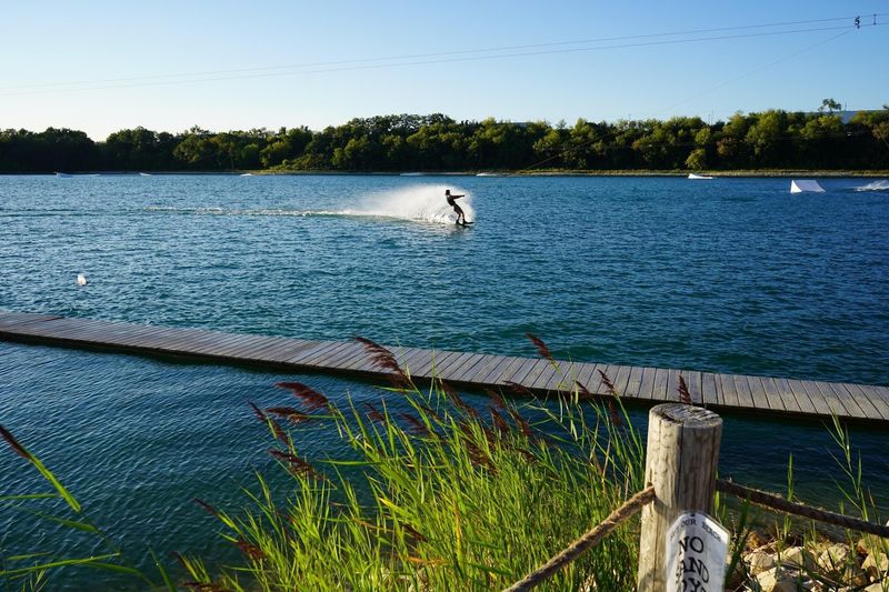 Wakeboarders Flying Over the Far Shore