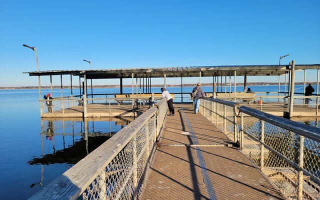 This Oklahoma Lake Has a Big Fishing Dock With Benches Where Anglers Keep Reeling Them In