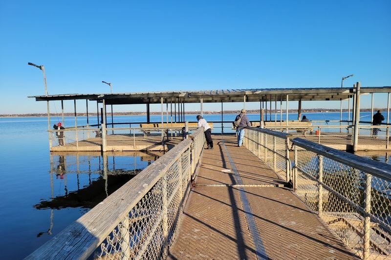This Oklahoma Lake Has a Big Fishing Dock With Benches Where Anglers Keep Reeling Them In