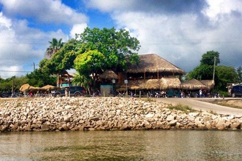 This Texas Hangout Serves Grilled Oysters Under Tiki Huts on Galveston Bay, With Weekend Live Music